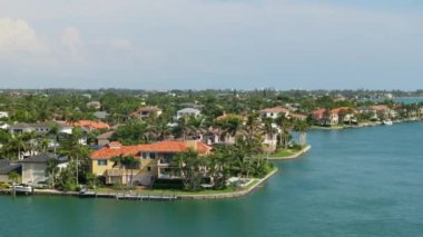 Sarasota, Florida 'daki yeşil palmiye ağaçları ve kenetlenmiş yatlar arasındaki pahalı deniz manzaralı evler. ABD 'de birinci sınıf konut geliştirme.