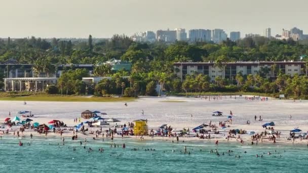 米国サラソータ州の柔らかい白い砂と有名なシエスタキービーチ 暖かい湾の水で入浴し 熱いフロリダの太陽の下で日焼けを楽しんでいる多くの人々 — ストック動画