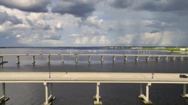 Aerial view of Barron Collier Bridge and Gilchrist Bridge in Florida with moving traffic. Transportation infrastructure in Charlotte County connecting Punta Gorda and Port Charlotte over Peace River.
