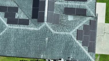 Banliyö bölgesinde temiz ekolojik elektrik enerjisi üretmek için çatısı güneş fotovoltaik panellerle kaplı Amerika 'daki sıradan bir ev. Özerk konut kavramı.