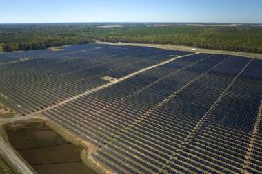 Temiz elektrik enerjisi üretmek için sıra sıra güneş fotovoltaik panelleri olan sürdürülebilir büyük elektrik santralinin havadan görünüşü. Sıfır emisyonlu yenilenebilir elektrik kavramı.