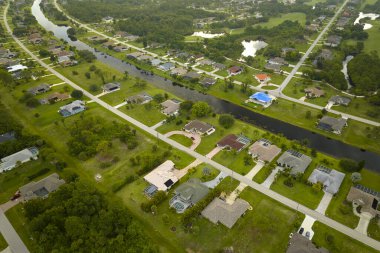 Florida 'nın sakin kırsal kesimindeki yeşil palmiye ağaçları arasındaki banliyö özel evlerinin hava manzarası.