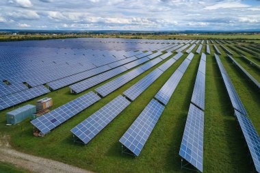 Temiz elektrik enerjisi üretmek için birçok sıra güneş fotovoltaik paneli bulunan sürdürülebilir büyük elektrik santralinin havadan görünüşü. Sıfır emisyon kavramı ile yenilenebilir elektrik.
