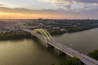 Ohio, ABD 'nin Cincinnati şehrinin şehir merkezindeki gece şehir manzarası. Köprüde arabaları süren ve modern Amerikan megapolis 'inde gökdelenleri aydınlatan gökdelenler..