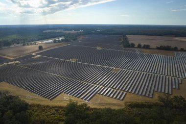 Temiz elektrik enerjisi üretmek için birçok sıra güneş fotovoltaik paneli bulunan sürdürülebilir büyük elektrik santralinin havadan görünüşü. Sıfır emisyon kavramı ile yenilenebilir elektrik.