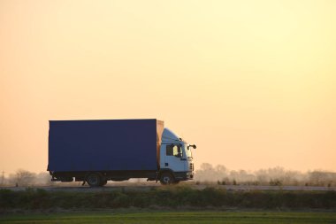 Kargo kamyonu akşamları otobanda mal taşıyor. Teslimat ulaşım ve lojistik kavramı.