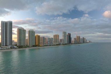 Günbatımında Sunny Isles Sahili 'nde Atlantik Okyanusu kıyısındaki kumlu deniz kıyısında pahalı oteller ve apartmanlar. Güney Florida 'daki Amerikan turizm altyapısı.