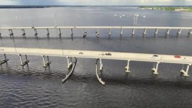 Aerial view of Barron Collier Bridge and Gilchrist Bridge in Florida with moving traffic. Transportation infrastructure in Charlotte County connecting Punta Gorda and Port Charlotte over Peace River.