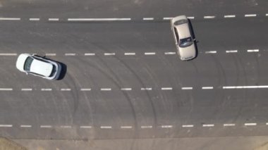 Beyaz işaretli ve hızlı sürüş arabalı şehir caddesinin havadan görünüşü. Şehir trafiğinin insansız hava aracının üst görüntüsü.