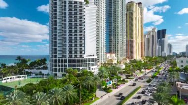 Sunny Isles Sahili 'nin havadan manzarası kalabalık sokak trafiği lüks oteller ve Atlantik Okyanusu kıyısındaki apartmanlar. Güney Florida 'daki Amerikan turizm altyapısı.