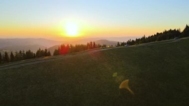 Güneş batan dağ manzarası, turist kamp çadırları ve güneşli bir akşamda tepedeki kamp alanında bir SUV arabası. Off-road macerası.
