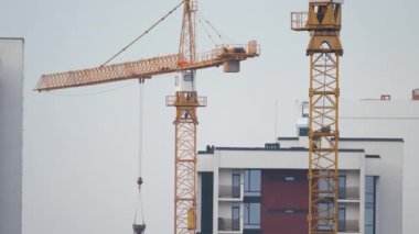 Yüksek konutlu apartman şantiyesindeki vinçler. Gayrimenkul geliştirme.