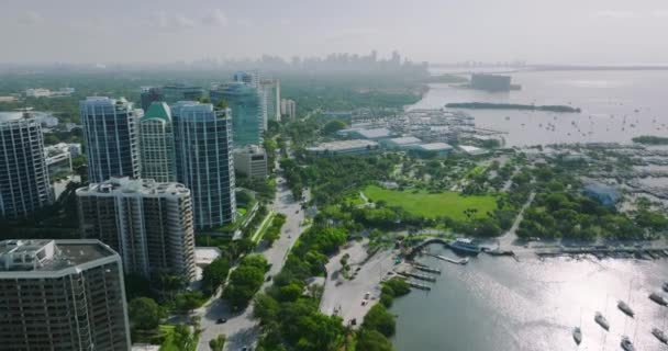 マイアミ市ココナッツグローブは アメリカ合衆国フロリダ州の高級地区で ボートとヨットがビスケイン湾のディナーキーマリーナにドッキングされました 現代アメリカのメガポリスの住宅マンションの建物 — ストック動画