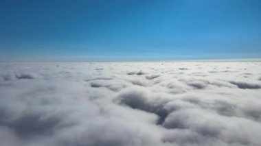 Dünya 'nın yüksek irtifasında, yağmur fırtınasından önce oluşan kabarık kümülüs bulutlarıyla kaplı uçak penceresinden hava görüntüsü.