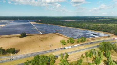Temiz elektrik enerjisi üretmek için sıra sıra güneş fotovoltaik panelleri olan sürdürülebilir büyük elektrik santralinin havadan görünüşü. Sıfır emisyonlu yenilenebilir elektrik kavramı.
