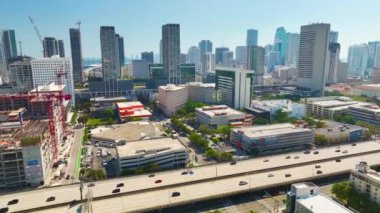 Miami, Florida 'da hızlı sürüş arabaları olan geniş otoban üzerinde gökdelen binaları olan Amerikan kentsel manzarası. ABD ulaşım altyapısının üstünden görüntüle.
