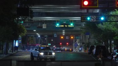 Trafik ışıkları ve gece hareket halindeki arabalarla dolu Amerikan kavşağı. ABD 'de ulaşım sistemi.