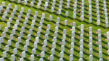 Büyük Amerikan askeri mezarlığı. Yeşil çimlerin üzerinde beyaz mezar taşları var. Anma Günü konsepti.