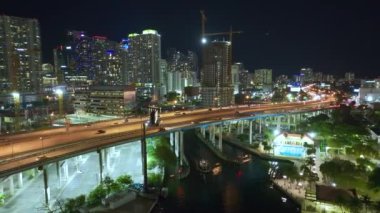 Miami, Florida 'da hızlı sürüş araçları olan gece geniş otoban üzerinde yüksek binaları olan modern Amerikan şehri. ABD kentsel altyapısının hava görüntüsü.