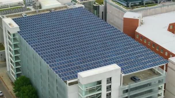 駐車場のガレージの上に日陰屋根として設置されたソーラーパネルから発生するグリーン電力 都市インフラに統合された太陽光発電技術 — ストック動画