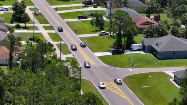 在美国佛罗里达州的一个小镇上 乡村道路上开着交通车辆 安静住宅区绿树与郊区街道之间的私人住宅 — 图库视频影像