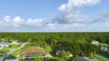 Florida 'nın sakin yerleşim bölgesinde yeşil palmiye ağaçları arasında özel evleri olan küçük bir Amerikan banliyö manzarası..