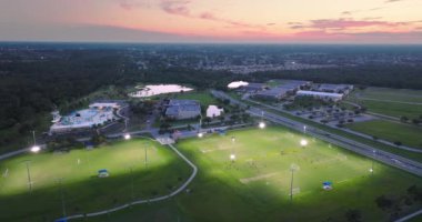 Kuzey Port, Florida 'da halk spor sahasında gün batımında çimen futbol stadyumunda futbol oynayan insanlarla aydınlandı. Açık hava aktiviteleri konsepti.