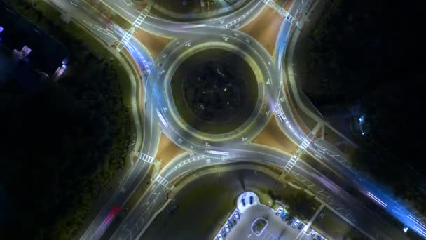 城市街道交通的顶部景观在环路交叉口在夜间与快速移动的汽车 照明城市环形交通交叉口的时间 — 图库视频影像