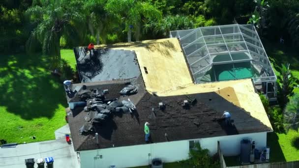 古いアスファルトシングルをプライベートハウスの屋上に新しいものに変更する労働者 フロリダの家の屋根の修理 不動産開発コンセプト — ストック動画