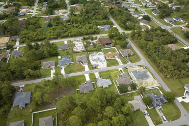 Aerial landscape view of suburban private houses between green palm trees in Florida quiet rural area.