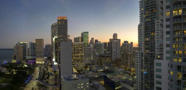 Florida, ABD 'de Miami Brickell şehir merkezinin hava görüntüsü. Günümüz Amerika 'sında arabaları ve metro trafiği ile aydınlık gökdelen binaları ve caddeleri.