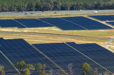 Temiz elektrik enerjisi üretmek için sıra sıra güneş fotovoltaik panelleri olan sürdürülebilir büyük elektrik santralinin havadan görünüşü. Sıfır emisyonlu yenilenebilir elektrik kavramı.