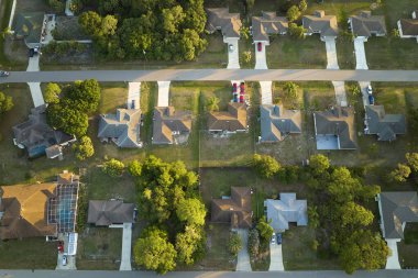 Florida sakin yerleşim bölgesinde yeşil palmiye ağaçları arasında özel evleri olan banliyö manzarası.