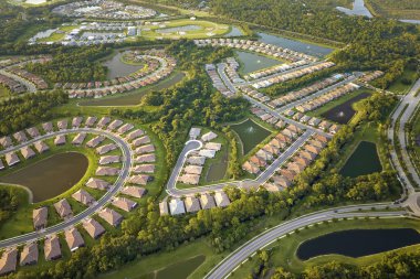 Florida 'da göl suyu olan kapalı yaşam kulüplerinin hava manzarası. Amerikan banliyölerinde emlak gelişimine örnek olarak aile evleri.