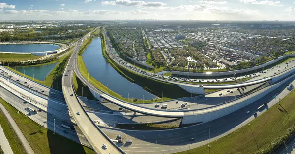 Above view of wide highway crossroads in Miami, Florida with fast driving cars. USA transportation infrastructure concept.