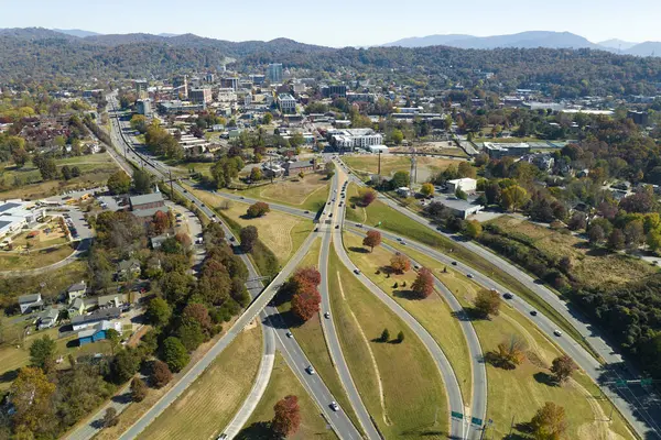 Aerial view of american freeway intersection in fall season in Asheville, North Carolina with fast moving cars and trucks. USA transportation infrastructure concept.