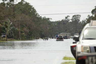 Amerikan caddesini, Florida yerleşim bölgesinde suyla çevrili hareket halindeki araçlarla doldurdu. Kasırga doğal felaketinin sonuçları..