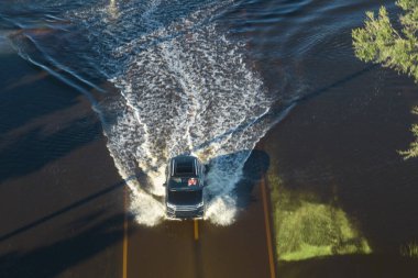 Şiddetli sağanak yağıştan sonra Florida 'da sel basmış yol. Tahliye araçlarının hava görüntüsü ve banliyö yerleşim bölgesindeki su evleri ile çevrili..