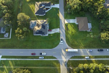 Standart Amerikan okul otobüslerinin en üst görüntüsü sabah erken saatlerde kasaba merkezindeki sokak durağından çocukları alıyor. ABD 'de toplu taşıma.
