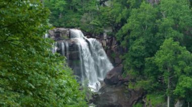 Nantahala Ulusal Ormanı 'ndaki kayalık kayaların arasına temiz su dökülen büyük şelaledeki orman sularıyla muhteşem bir yaz manzarası. Whitewater Şelalesi, Kuzey Carolina, ABD.