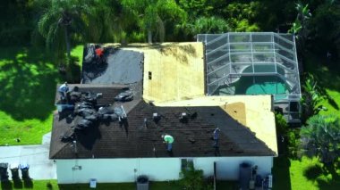 İnşaat işçileri özel evin çatısındaki asfalt kiremitleri söküyorlar. Florida 'daki evde çatı tamiri. Gayrimenkul geliştirme kavramı.