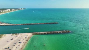 Venedik ve ABD 'nin Sarasota ilçesindeki Nokomis plajı yakınlarındaki renkli okyanus sularında limanda kaya iskelesi bariyeri ve tekneler denize açılıyor..