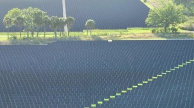 Temiz elektrik enerjisi üretmek için birçok sıra güneş fotovoltaik paneli bulunan sürdürülebilir büyük elektrik santralinin havadan görünüşü. Sıfır emisyon kavramı ile yenilenebilir elektrik.