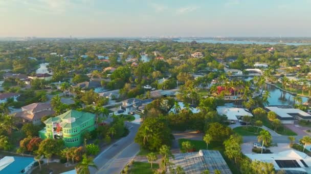 緑のヤシの木とフロリダ州サラソータのドッキングヨットの間の高価なウォーターフロントハウスの空中ビュー 米国におけるプレミアム住宅開発 — ストック動画
