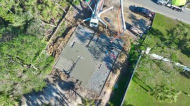 Yeni ev inşaatındaki işçilerin havadan görünüşü duvarlar ve çatı için beton döşeme temelleri döşemeye hazır..