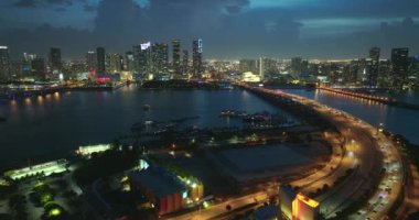 Gece yarısı Miami, Florida 'daki geniş otoyol köprüsünde Amerikan şehrinde yoğun trafik vardı. Kentsel ulaşım altyapısı üzerine gökdelen binaları.