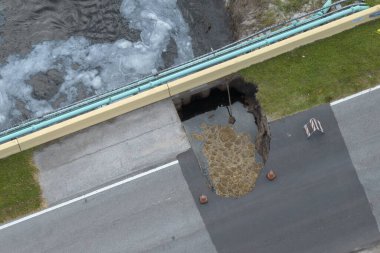 Florida 'da kasırga üstüne köprü yıkıldı. İnşaat alanı inşaatı. Sel sularının asfaltı temizlemesinden sonra hasarlı yolun yeniden inşası.