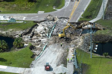 Yol çalışması alanında inşaat malzemeleri. Sel suları asfaltı yıkadıktan sonra yıkılan hasarlı yol köprüsünün yeniden inşası. Yıkılmış ulaşım altyapısının yeniden inşası.