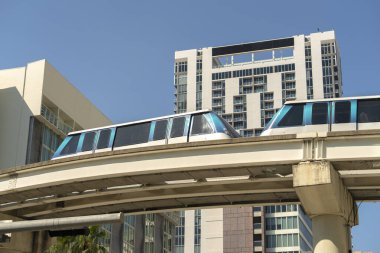 Modern Amerikan megapolis 'inde gökdelen binaları arasında yüksek demiryolu üzerindeki şehir vagonu. Florida 'nın Miami Brickell semtinde şehir ulaşımı..