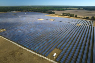 Temiz elektrik enerjisi üretmek için sıra sıra güneş fotovoltaik panelleri olan sürdürülebilir büyük elektrik santralinin havadan görünüşü. Sıfır emisyonlu yenilenebilir elektrik kavramı.